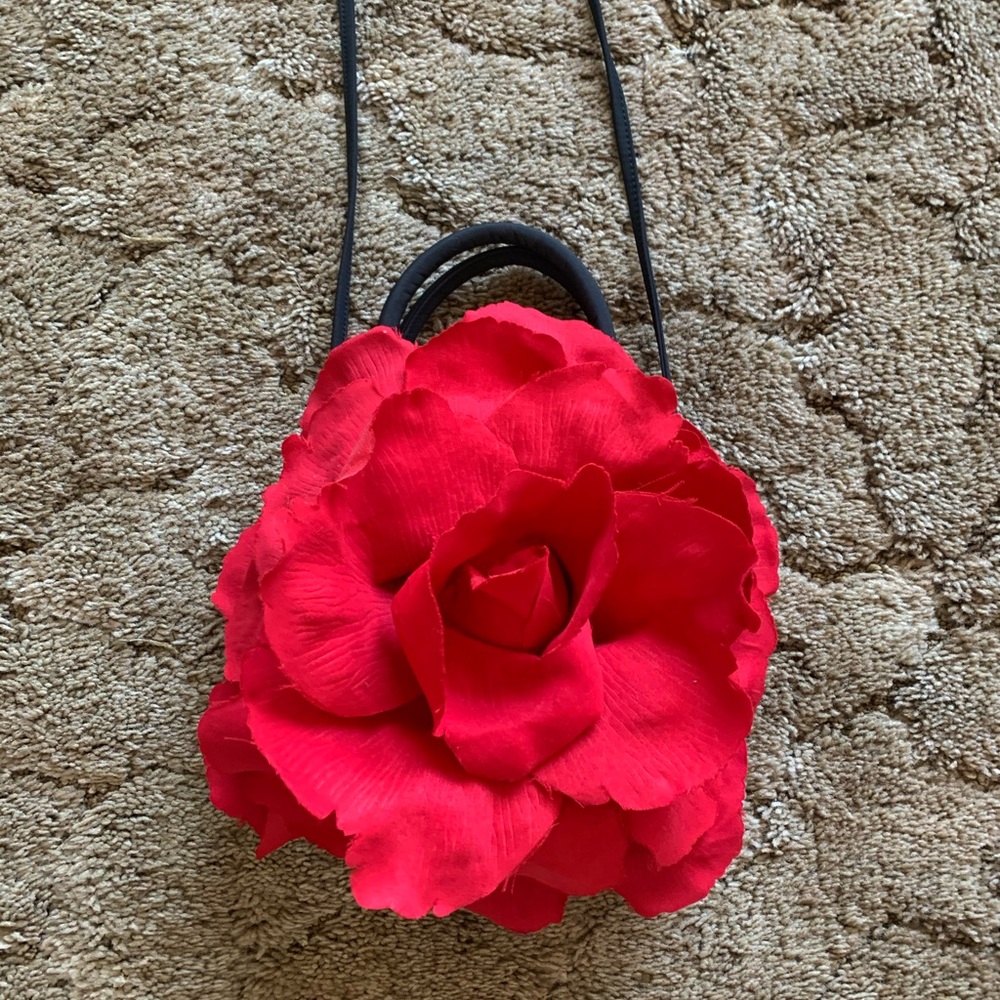 A black handbag with red rose